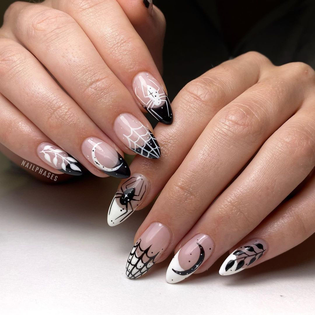 Black, pink, and white colored nails with leaves, moons, spiders, and webs.