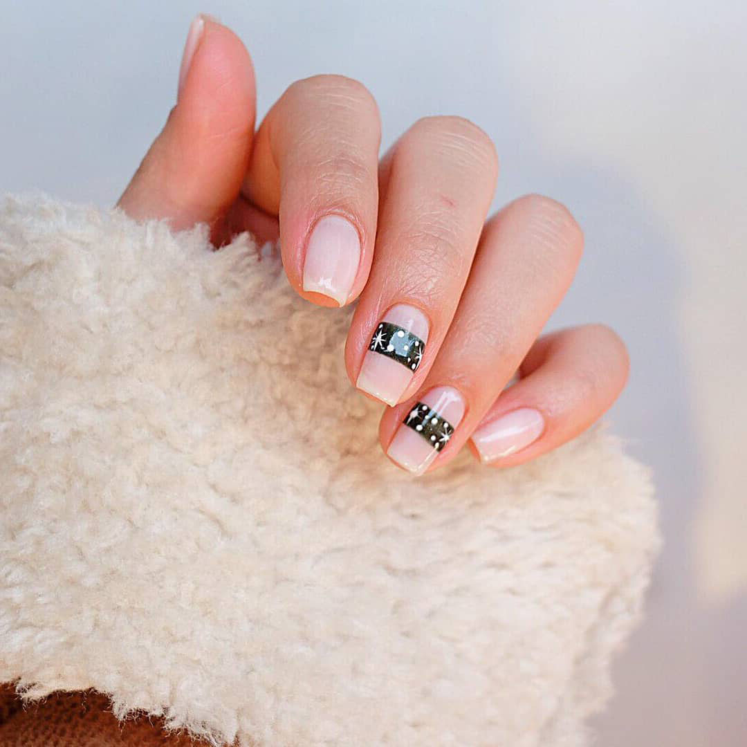 Nails with a black strip with snowflakes.
