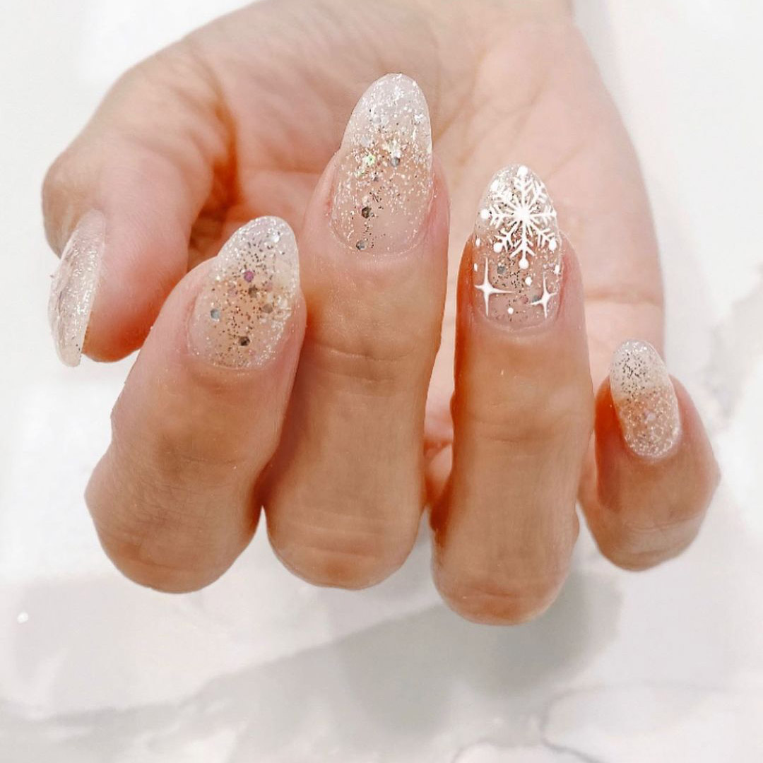 Nails with gold glitter and silver dot nail polish for the snowflake design.