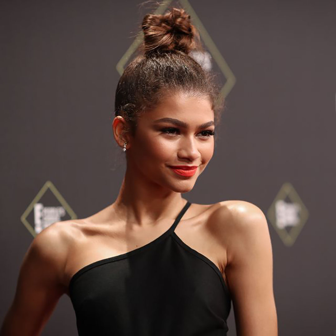 Zendaya with a wispy bun hairstyle.