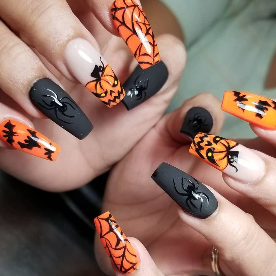 Orange and black colored nails with bats, spiders, pumpkins, and webs.
