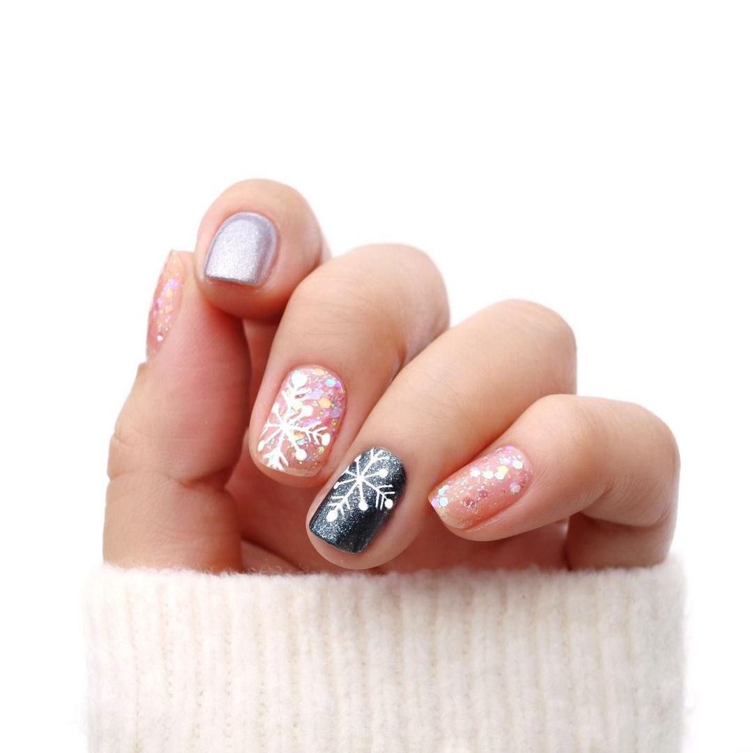 Nails with navy blue and pink snowflakes.
